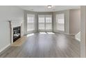 Bright and airy living room featuring a fireplace, three large windows and light vinyl plank flooring at 3637 Chinaberry Ln, Snellville, GA 30039