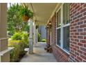 Cozy front porch with brick columns, hanging ferns, and decorative mushroom accents at 3876 Thackary Dr, Powder Springs, GA 30127