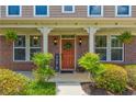 Inviting front porch featuring brickwork, decorative plants, and a welcoming front door with wreath at 3876 Thackary Dr, Powder Springs, GA 30127