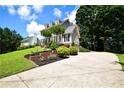View of this beautiful home featuring manicured landscaping, a winding driveway, and a peek at the home's side entry garage at 5040 Puritan Dr, Sugar Hill, GA 30518