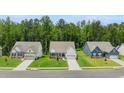 Street view of newly built homes featuring manicured lawns and wide driveways in quiet neighborhood at 51 Black Rock Rdg, Sharpsburg, GA 30277