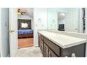 Bright bathroom featuring a large vanity with double sinks, view to the bedroom, and a walk-in closet at 737 Wilkes Dr, Loganville, GA 30052