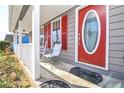 The front door of the house has a white frame, and a large oval glass in the middle, flanked by windows with red shutters at 737 Wilkes Dr, Loganville, GA 30052