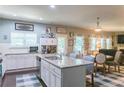 Stylish kitchen featuring a granite countertop island with seating, white cabinets, stainless steel appliances, and a dining area at 6695 Grove Meadows Ln, Cumming, GA 30028