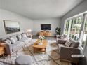 Bright, virtually staged living room with a large window, stylish furniture, and neutral decor at 540 Stockwood Dr, Woodstock, GA 30188