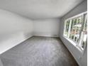 Bright living room featuring a large window providing lots of natural light and neutral carpeting at 540 Stockwood Dr, Woodstock, GA 30188