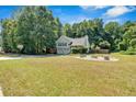Spacious front yard featuring a lush lawn, basketball court, and a cozy firepit area, great for outdoor entertainment at 127 Muirwood Dr, Temple, GA 30179