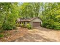 Single Gathering home exterior featuring a garage and neutral siding with lush surrounding landscape at 1832 Tree Top Ct, Marietta, GA 30062