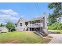View of a quaint home featuring gray siding, a white-railed porch and landscaped front yard at 28 Fawn Ct, Sharpsburg, GA 30277