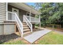 Exterior view showcasing the home's entrance with steps, a porch, and landscaping at 28 Fawn Ct, Sharpsburg, GA 30277