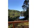 Scenic view of a serene lake surrounded by lush trees, seen from a private deck at 4380 Serenity Lake Dr, Cumming, GA 30028