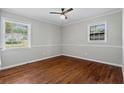 Inviting bedroom with hardwood floors, a ceiling fan, and ample natural light from two windows at 4090 Tara Dr, Forest Park, GA 30297
