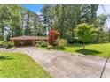 Long driveway leading to a brick home with attached carport and lush greenery at 5400 Francis Ave, Stone Mountain, GA 30087