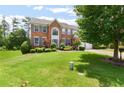 Charming two-story brick home boasts a lush green lawn, mature trees, and inviting curb appeal at 5003 Pacific Dunes Dr, Suwanee, GA 30024