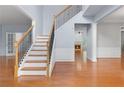 Bright foyer showcasing hardwood floors, staircase with iron spindles, and open access to living spaces at 5003 Pacific Dunes Dr, Suwanee, GA 30024