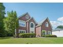 Inviting two-story brick home with a lush green lawn and mature trees in a suburban setting at 2268 Orleans Ave, Marietta, GA 30062