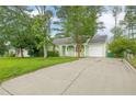Charming single-story home with a long driveway, attached garage, and lush front lawn at 1249 Riva Ridge Dr, Norcross, GA 30093
