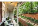 Inviting front porch with seating, surrounded by lush greenery and a winding stone path to the home at 2880 Foothill Trl, Marietta, GA 30066