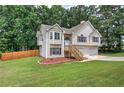 Charming split-level home featuring stone accents, wood shutters, and a two-car garage at 121 Paradise Circle, Douglasville, GA 30134