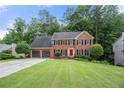 Charming two-story brick home featuring an attached two-car garage and a well-manicured lawn at 2214 Trilleck Nw Dr, Kennesaw, GA 30152