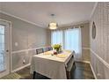 Charming dining room features modern light fixture, a table set for four, and stylish accent wall at 1202 Countryside Pl, Smyrna, GA 30080