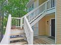 Exterior view of the condo featuring a light yellow exterior, white stair railings, and a front door at 1202 Countryside Pl, Smyrna, GA 30080