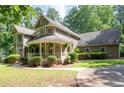 Charming home with a wraparound porch that enhances the appeal of the property, complemented by lush landscaping at 220 Mars Hill Rd, Powder Springs, GA 30127