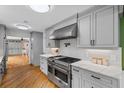 Stylish kitchen featuring gray cabinets, stainless steel appliances, marble countertops, and hardwood floors at 555 Valley Hall Dr, Atlanta, GA 30350