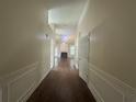 Long hallway featuring wood floors and white paneled walls leading to living room at 76 Daisy Meadow Trl, Lawrenceville, GA 30044