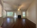 Spacious living room with fireplace, ceiling fan, hardwood floors, and large windows at 76 Daisy Meadow Trl, Lawrenceville, GA 30044