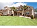 Inviting brick home with lush green lawn and mature palm trees, showcasing Southern charm at 1227 Castle Point Sw Ct, Conyers, GA 30094