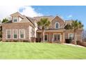 Beautiful two-story brick home with manicured lawn and palm trees enhancing curb appeal at 1227 Castle Point Sw Ct, Conyers, GA 30094