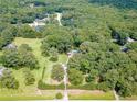 Aerial view of a sprawling wooded property featuring a pool, home, and long driveway at 7234 Post Rd, Winston, GA 30187