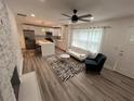 Spacious living room with fireplace, ceiling fan, and modern open kitchen with a kitchen island at 876 Pinehurst Sw Ter, Atlanta, GA 30310