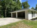Attached two-car carport with a concrete driveway and manicured flowerbeds enhance the exterior of this home at 3975 N Sharon Church N Rd, Loganville, GA 30052