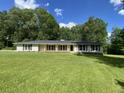 Inviting single-story home with a large, well-maintained front lawn and mature trees, offering a serene environment at 3975 N Sharon Church N Rd, Loganville, GA 30052