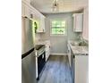 Contemporary kitchen featuring white cabinets, granite countertops, stainless steel appliances, and modern fixtures at 6906 Shangrila Way, Riverdale, GA 30296