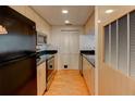 Efficient kitchen with wood cabinets, black appliances, and black countertops, all conveniently designed for easy cooking at 3481 Lakeside Ne Dr # 902, Atlanta, GA 30326