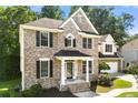 Charming brick home featuring black shutters, an attached garage, and a beautifully landscaped lawn at 733 Miller Run Run, Atlanta, GA 30349
