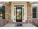 Elegant front door with decorative glass and brick surround provides a warm welcome at 733 Miller Run Run, Atlanta, GA 30349