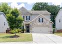 Inviting two-story home featuring brick and siding accents, a two-car garage, and a manicured lawn at 2099 Lakeview Bend Way, Buford, GA 30519