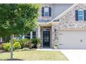 Close-up of the home's entryway, featuring a decorative door and well-kept landscaping at 2099 Lakeview Bend Way, Buford, GA 30519