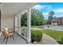 Inviting covered porch with cozy seating, offering a relaxing outdoor space and pleasant views at 3957 Marquette Nw Way, Kennesaw, GA 30144