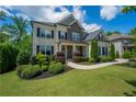 Landscaped front yard of a two-story home with a stone facade and black shutters at 3755 Valleyway Rd, Cumming, GA 30040