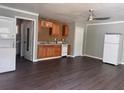 Open-concept living space with newer flooring, laundry closet, ceiling fan, and kitchen area with essential appliances at 499 Oak Way, Lawrenceville, GA 30046