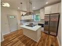 Modern kitchen with an island cooktop, stainless steel appliances, and white cabinets at 1497 Elizabeth Ln, East Point, GA 30344