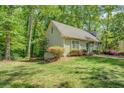 A view of the side yard showing a well-manicured lawn, mature trees, and the side of the house at 3957 Woodland Cir, Conyers, GA 30013
