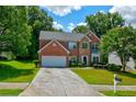 Charming two-story home with a brick facade, manicured lawn, and a convenient two-car garage at 5025 Bishops Row Row, Austell, GA 30106