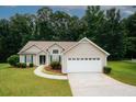 Lovely home with attached two-car garage and green shutters surrounded by mature trees at 555 Flintlock Dr, Dacula, GA 30019