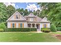 Charming home with well-manicured lawn surrounded by beautiful trees providing ample shade at 4825 Whispering Pine Way, Cumming, GA 30028